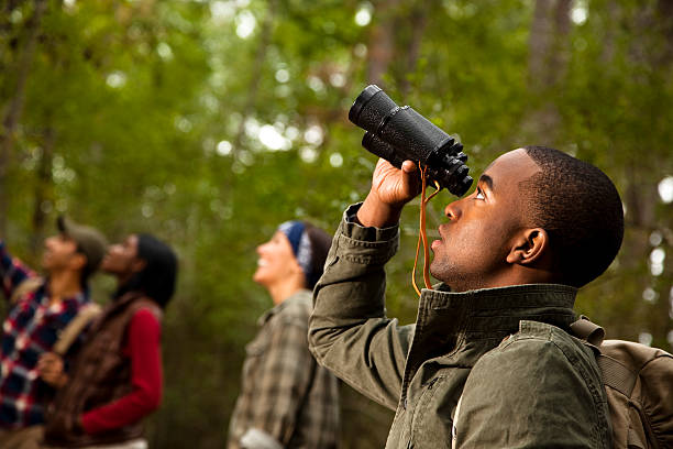 Group of friends camping and hiking using binoculars